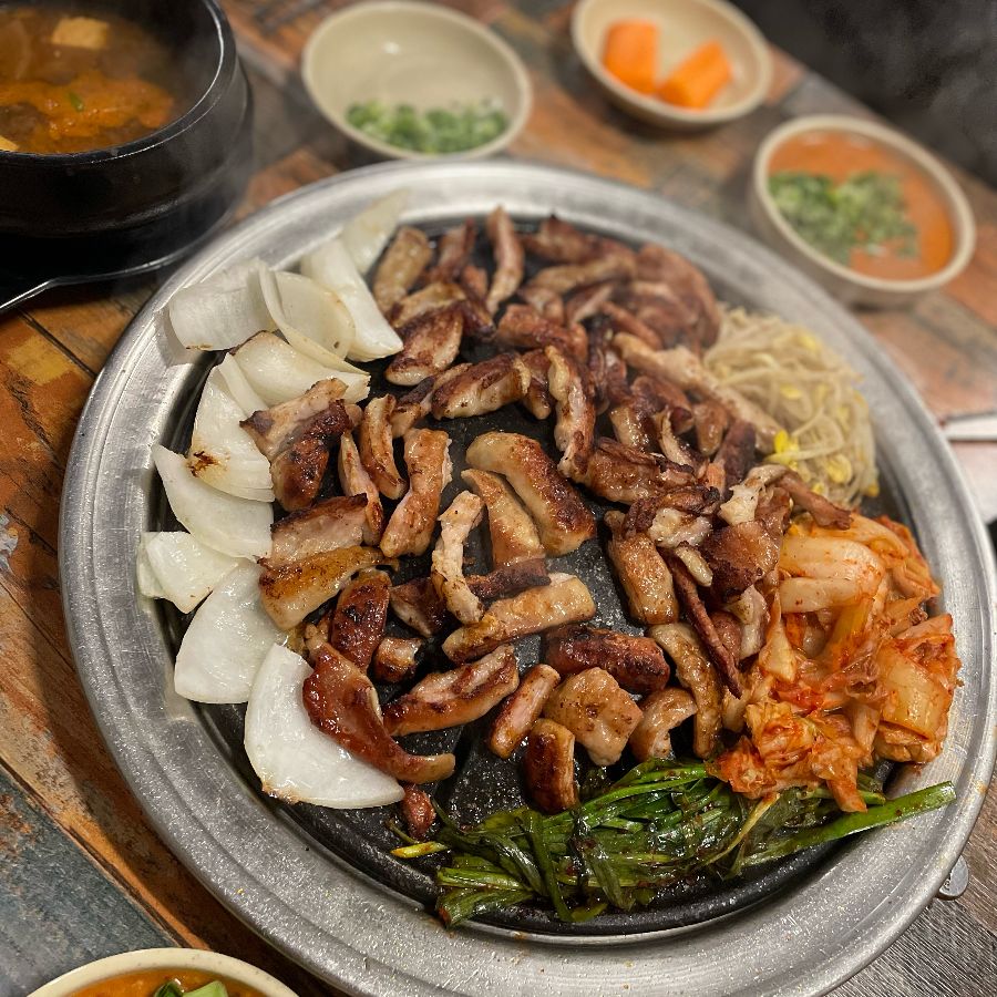 잘 구워진 막창과 뽈살을 다양한 곁들임 채소와 함께 즐기는 모습