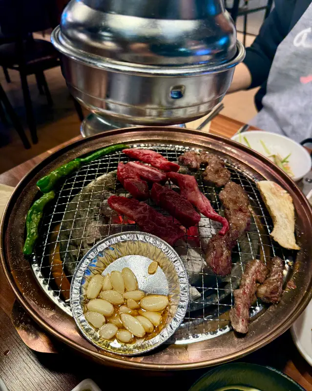 숯불 위에서 익어가는 갈비살과 마늘, 그리고 버섯