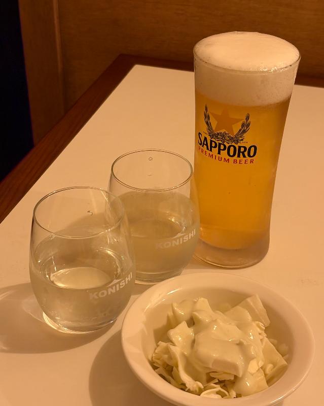 깔끔하게 정돈된 테이블 위 삿포로 생맥주와 곁들임