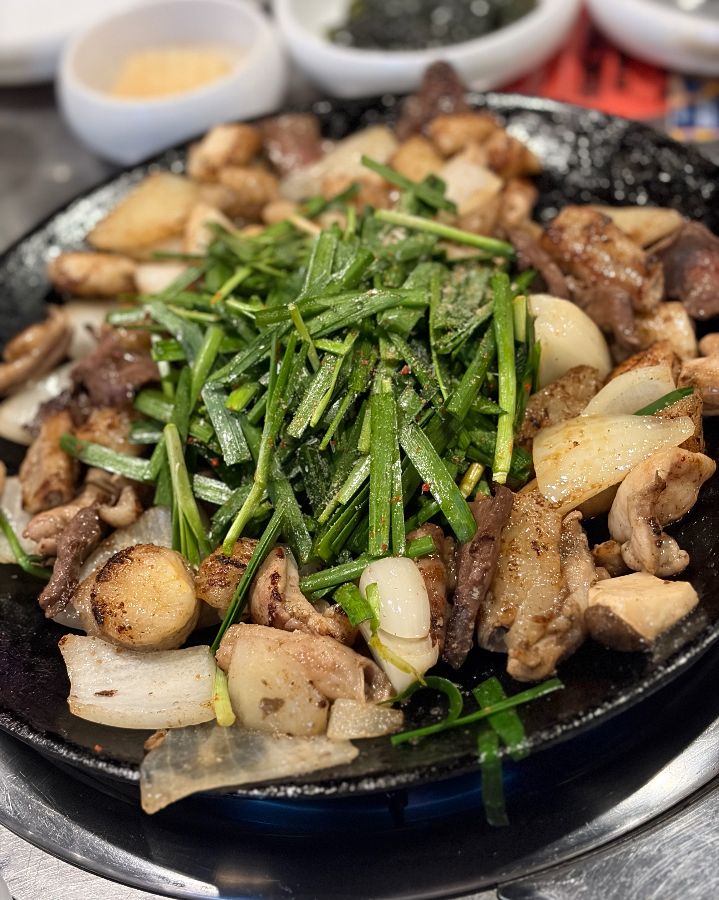 곱창, 떡, 감자, 양파, 김치, 부추가 돌판에 함께 구워져 나오는 모습