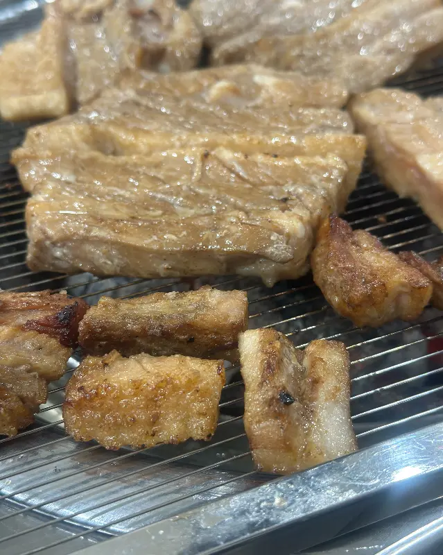 숯불 위에서 노릇하게 구워진 돼지갈비