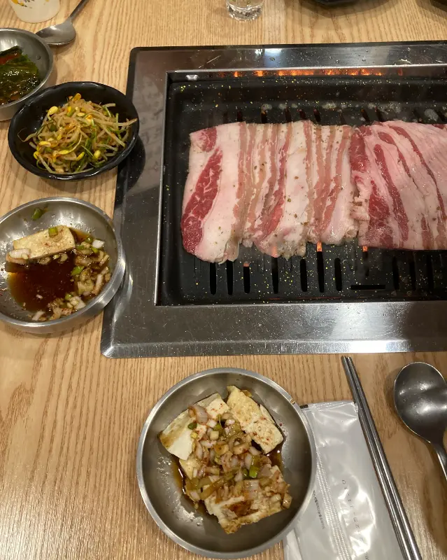 잘 구워진 우삼겹과 다양한 밑반찬들