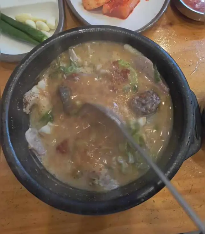 숟가락으로 순대국 내용물을 휘젓는 모습