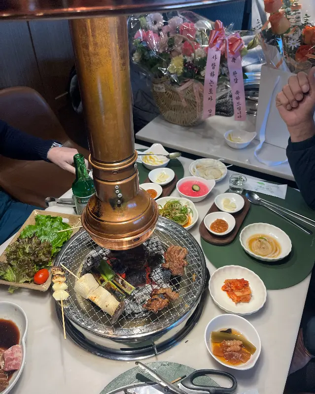 테이블 위에 놓인 화로와 정갈한 밑반찬