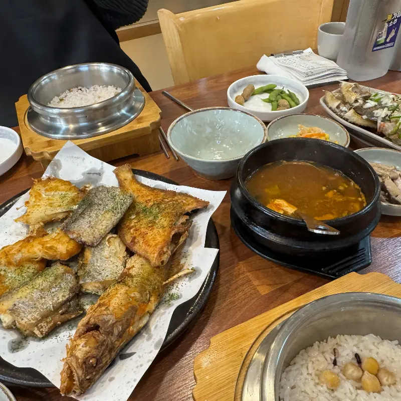 생선구이와 솥밥, 된장찌개, 다양한 밑반찬이 차려진 푸짐한 상차림