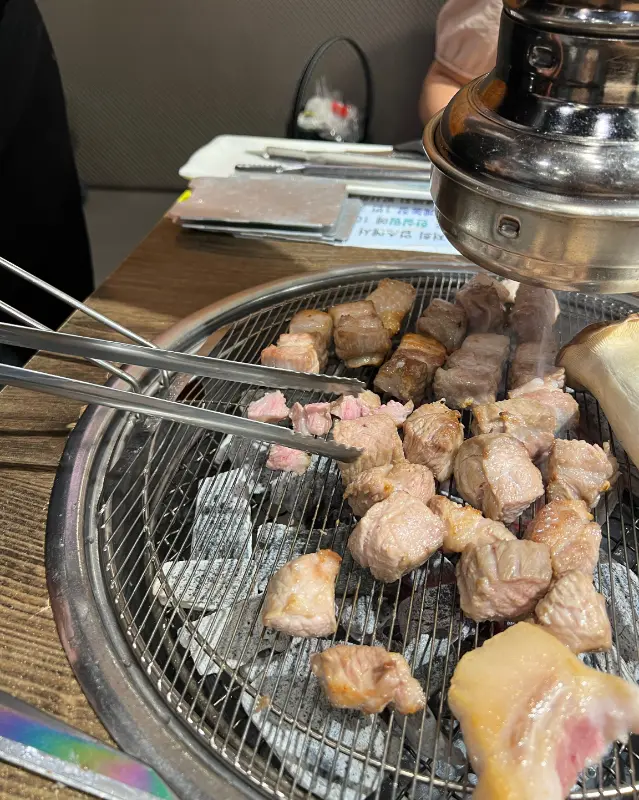 숯불 위에서 구워지고 있는 다양한 부위의 돼지고기