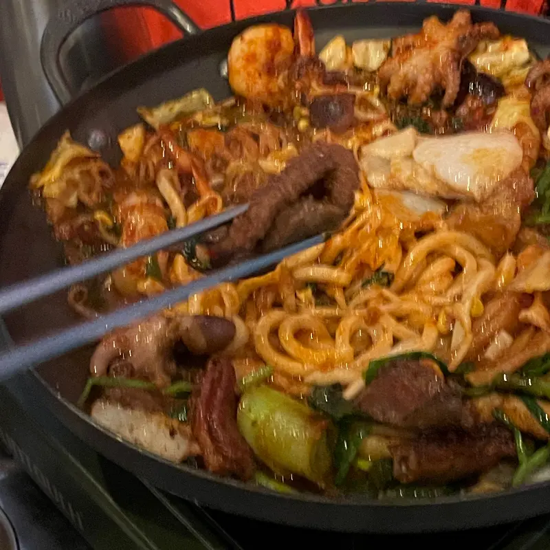 철판 위에 곱창, 쭈꾸미, 야채 등이 함께 볶아져 있는 모습