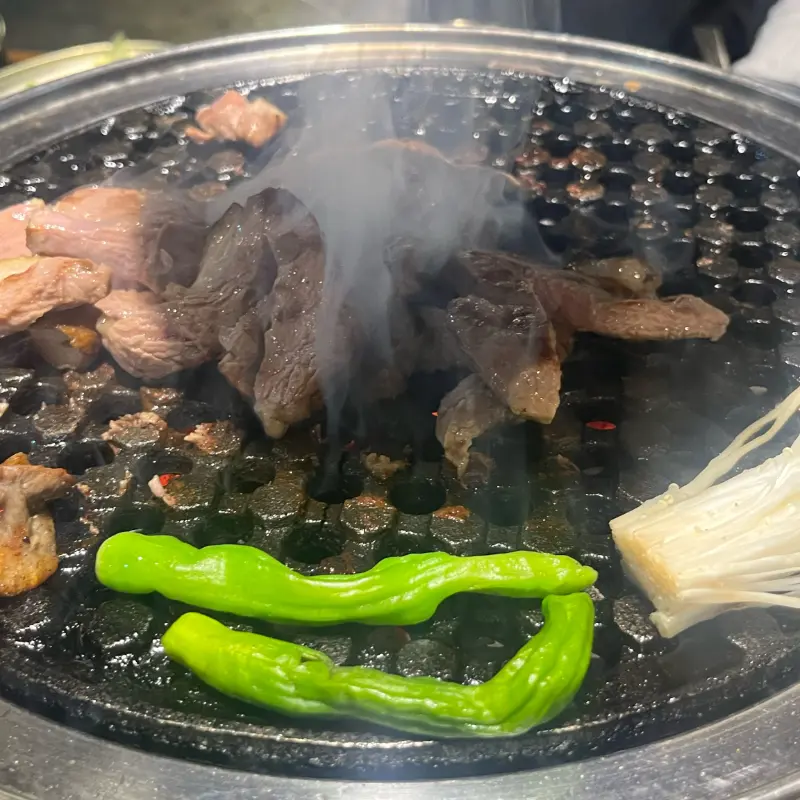 숯불 위에서 오리고기와 함께 구워지는 채소