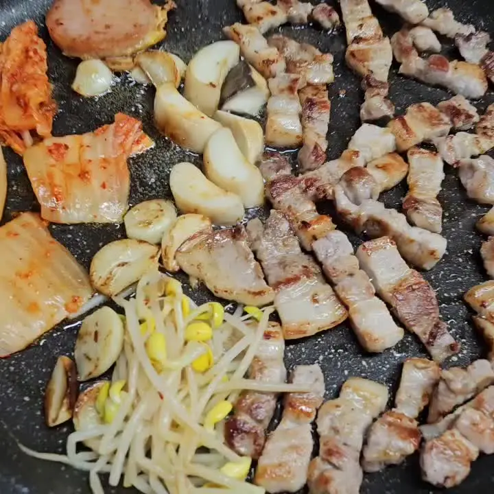 삼겹살 기름에 구워진 김치와 콩나물