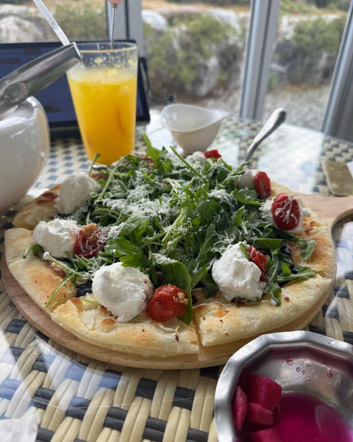 나무 도마 위에 놓인 리코타 샐러드 피자