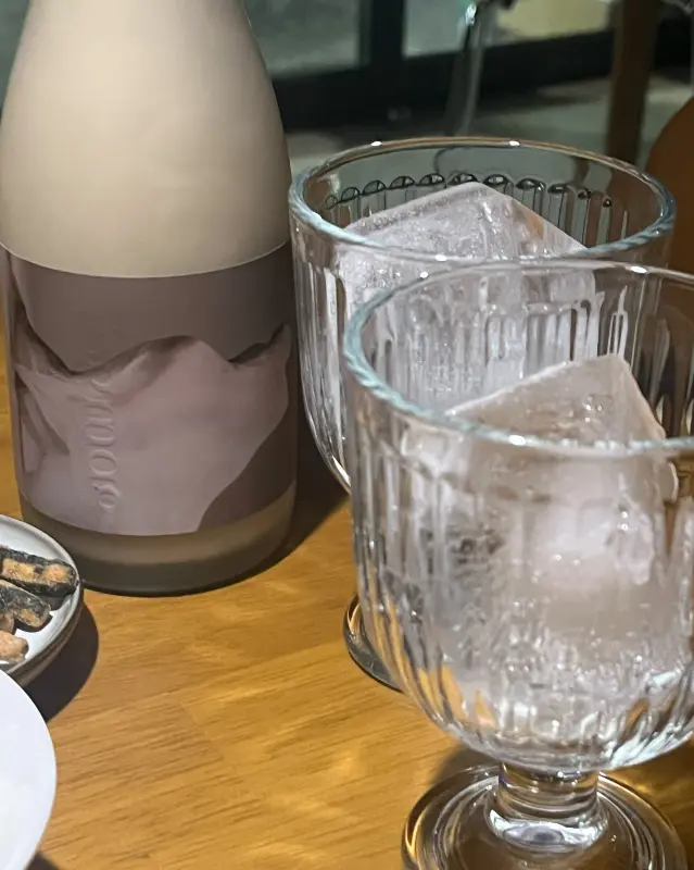 얼음이 담긴 잔과 포그막 막걸리 병