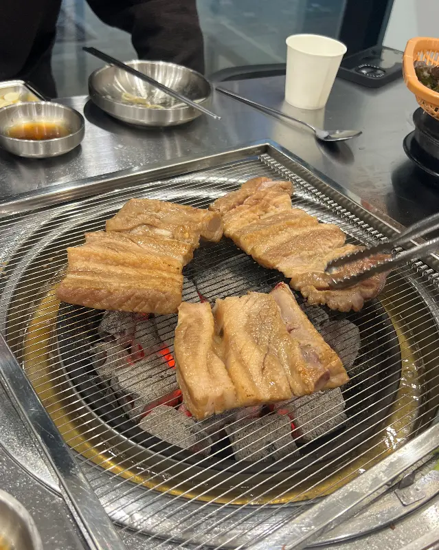 숯불 위에서 익어가는 윤슬갈비의 돼지갈비