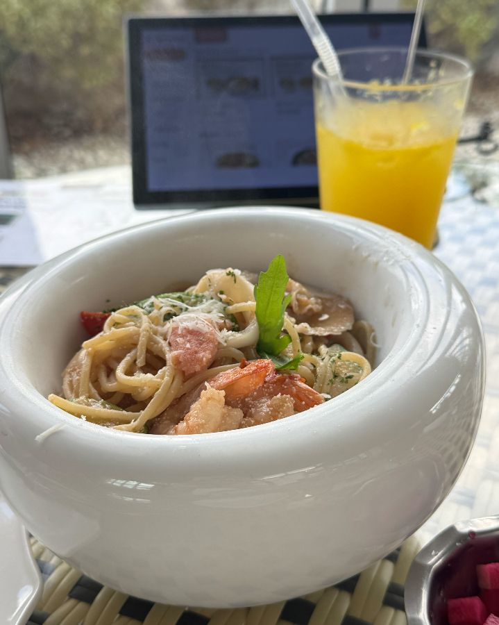 테이블 위에 놓인 명란 오일 파스타와 오렌지 주스