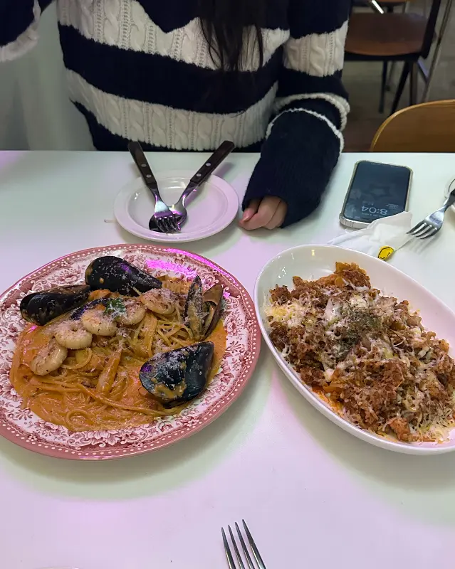 테이블 위에 놓인 김치오일파스타와 스테이크 리조또