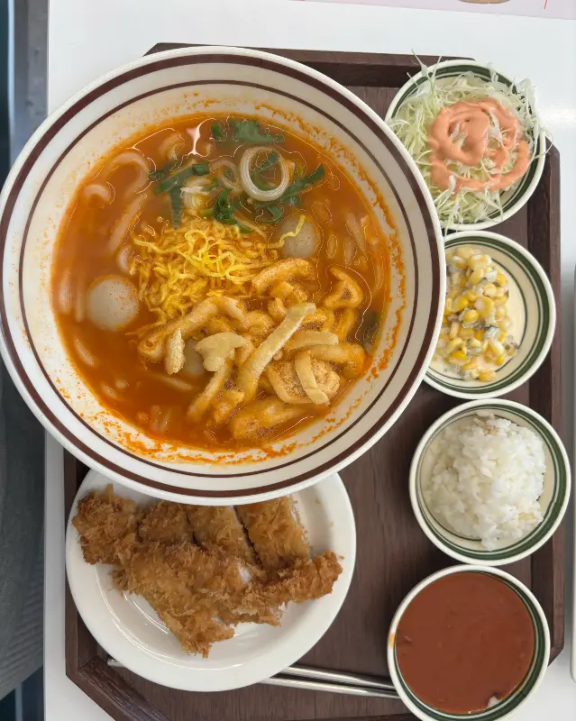 우동 면발이 카레 소스에 담겨 있고, 그 위에 휘핑크림이 올려진 카레 우동