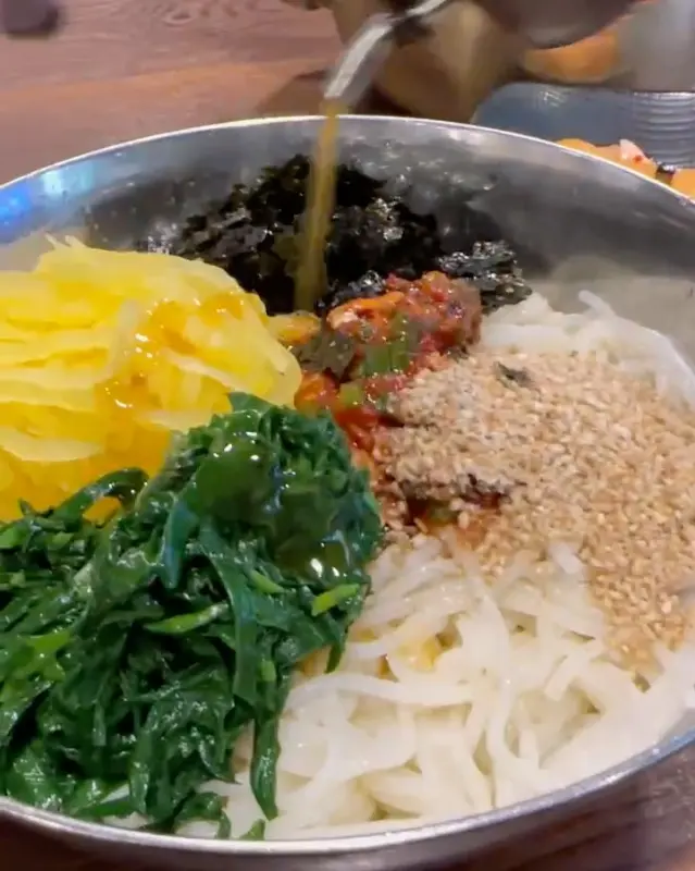 비빔국수에 육수를 부어 먹는 모습