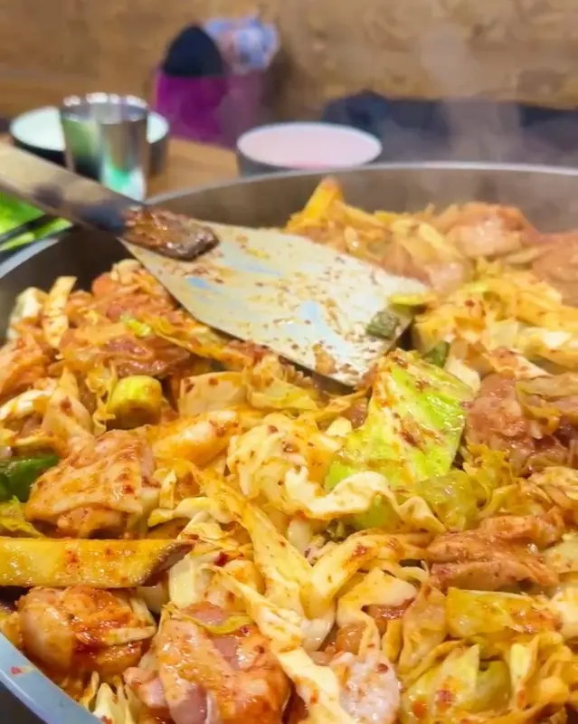 철판 위에서 익어가는 닭갈비의 모습