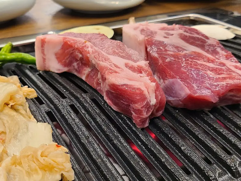 숯불 위에서 노릇하게 구워지고 있는 두툼한 목살