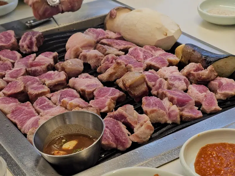 잘 구워진 목살이 불판 위에 가지런히 놓여 있는 모습