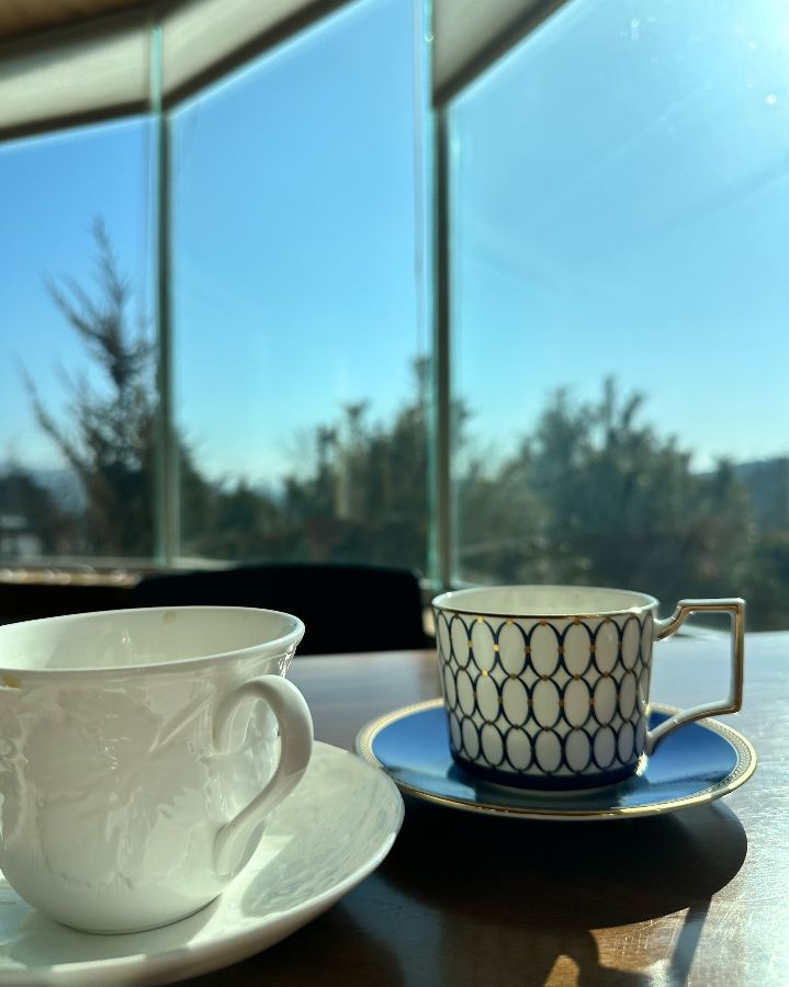 아브리에쎄르 창밖으로 보이는 아름다운 풍경과 커피잔