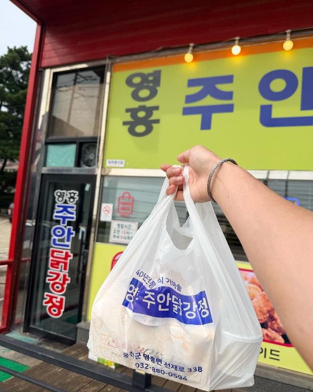 포장해 온 닭강정 봉투를 들고