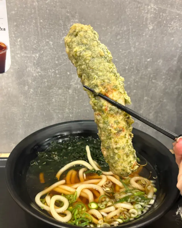 우동에 길게 튀겨진 어묵 튀김이 담겨있는 모습