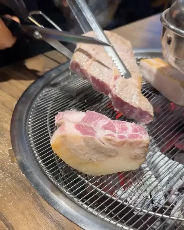 숯불 위에서 노릇하게 구워지는 두툼한 목살