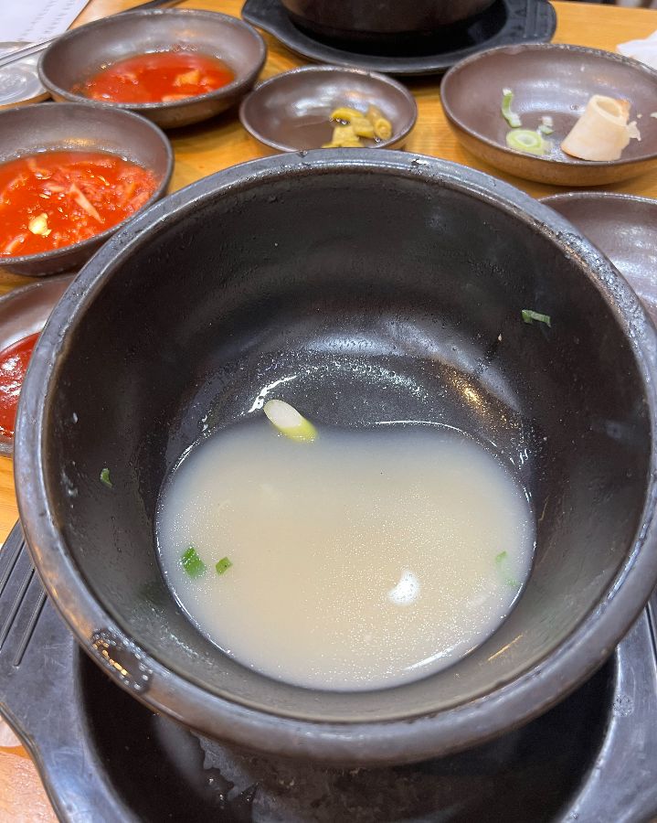 테이블 한가득 차려진 밑반찬과 우족탕