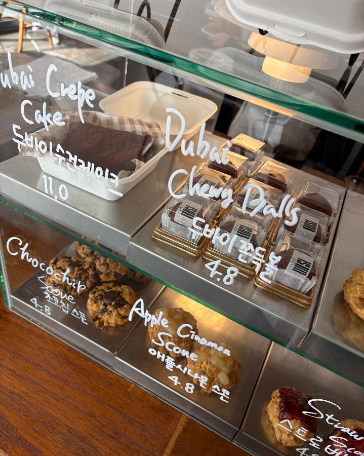 쇼케이스 안에는 두바이 크레페 케이크, 두바이 쫀득볼, 초코칩 쿠키, 애플 시나몬 스콘, 딸기 스콘 등 다양한 디저트가 진열되어 있다.