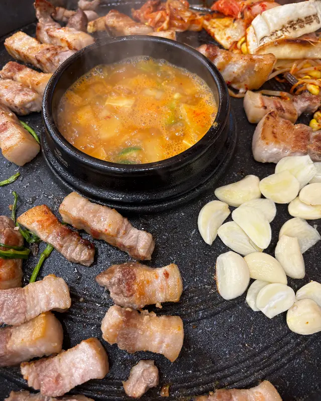 삼겹살과 함께 구워진 김치, 콩나물, 마늘