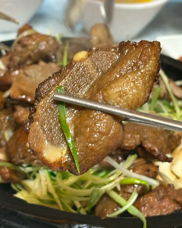 젓가락으로 들어올린 윤기 흐르는 돼지갈비