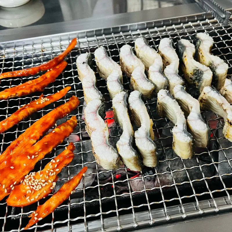 숯불 위에 구워지는 장어와 더덕구이