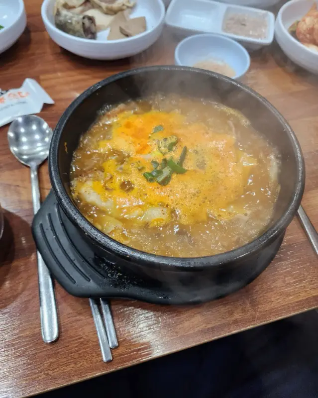 순대국이 담긴 검은 뚝배기에서 김이 모락모락 피어오르고 있다.