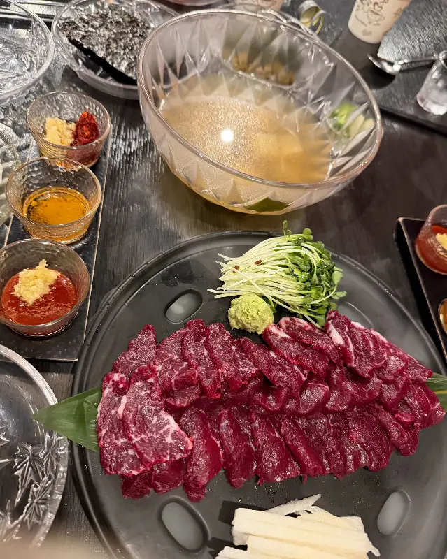 육사시미를 찍어 먹을 수 있는 다양한 소스가 작은 그릇에 담겨 쟁반 위에 놓여 있는 모습