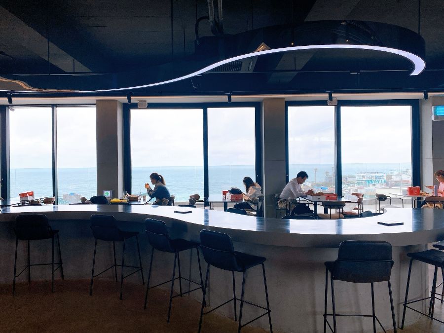 동경밥상 내부 바 테이블 좌석과 제주 바다 뷰
