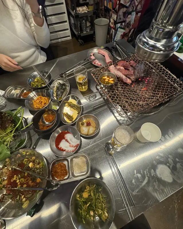 다양한 밑반찬과 고기가 가득한 테이블