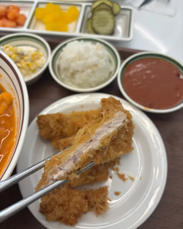 돈까스의 단면을 보여주는 사진, 고기의 두께와 튀김옷의 바삭함이 느껴진다.