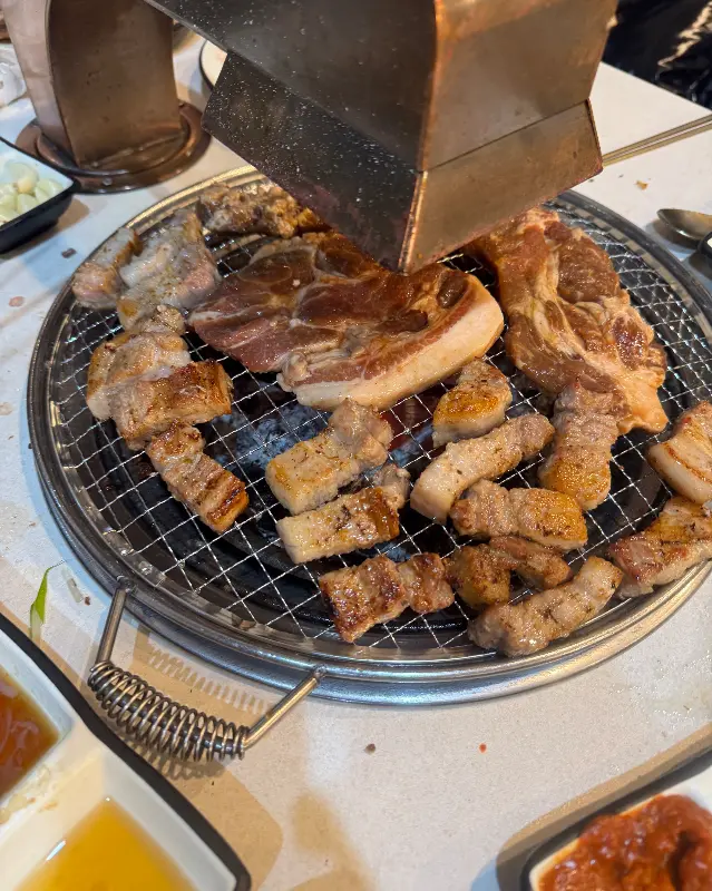 숯불 위에서 노릇하게 익어가는 삼겹살