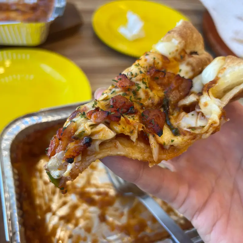 베이컨이 토핑된 피자 한 조각