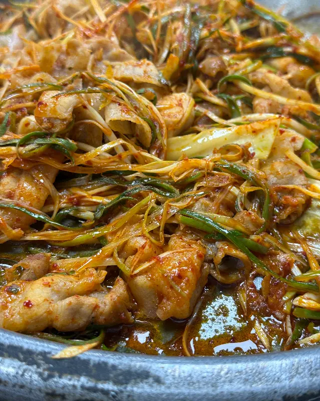 대패삼겹살과 파채가 양념에 버무려져 먹음직스럽게 익어가는 모습