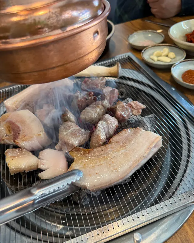 숯불 위에서 노릇하게 익어가는 흑돼지