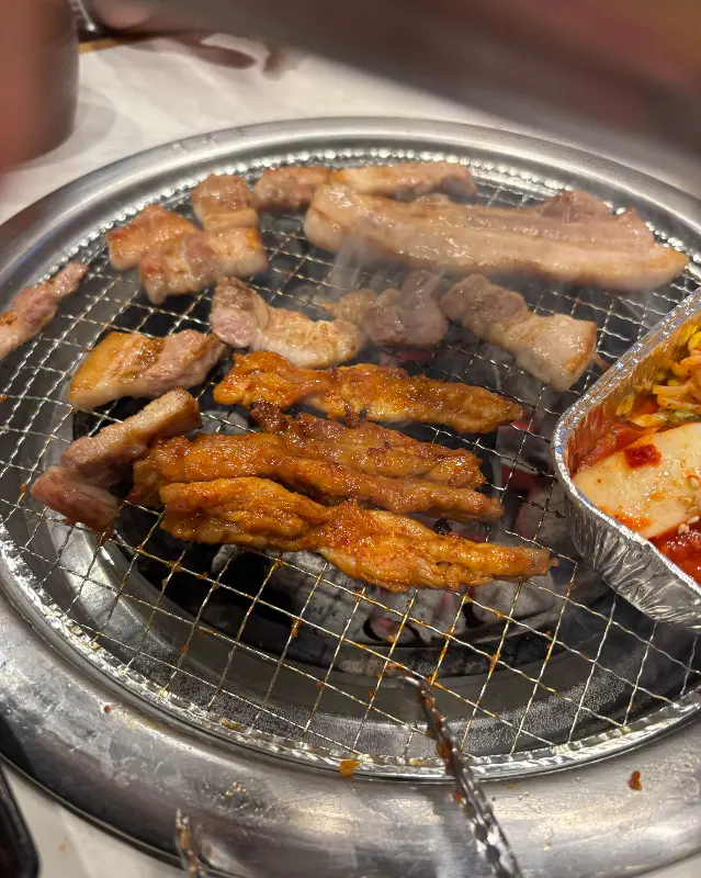 숯불 위에서 구워지는 닭목살과 돼지껍데기