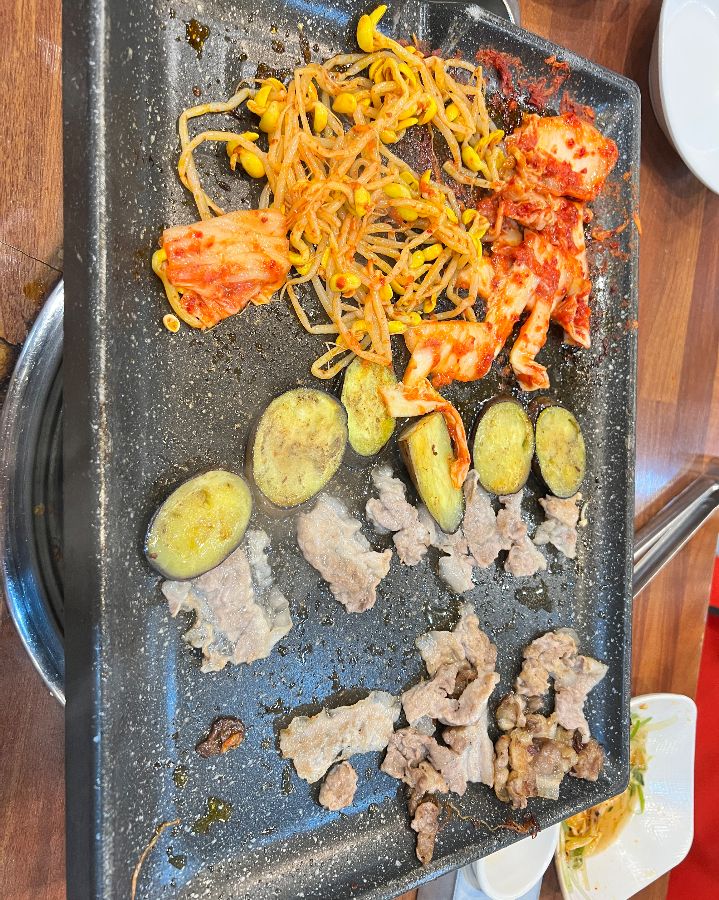 불판에 구워진 김치와 콩나물