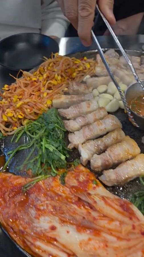 노릇하게 익어가는 삼겹살과 김치, 콩나물