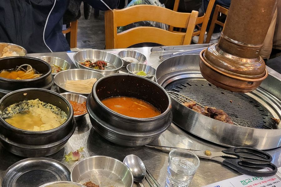 곁들임 메뉴와 숯불이 준비된 테이블