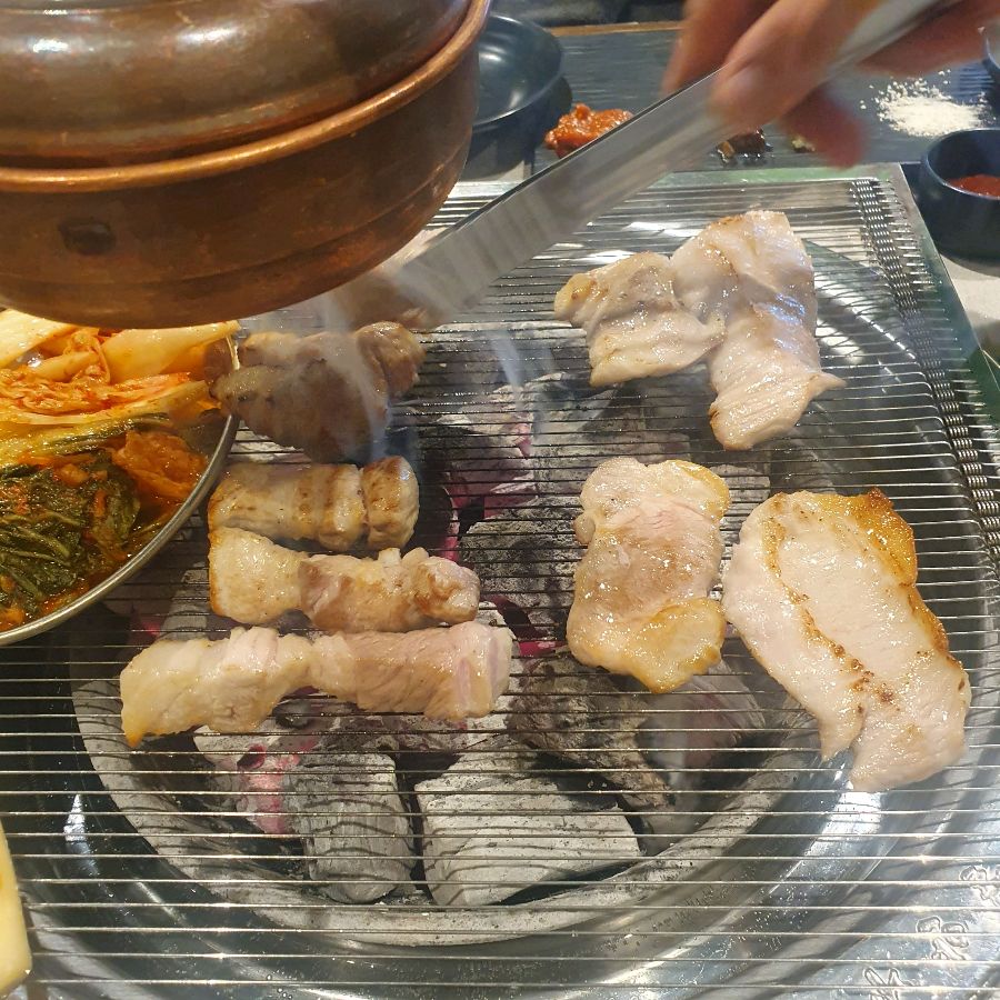 직원분이 능숙한 솜씨로 삼겹살을 굽고 있는 모습