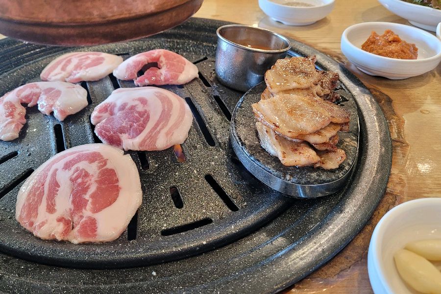 불판 한켠에 가지런히 구워져 있는 삼겹살 로스가 보기만 해도 군침이 돌게 합니다.