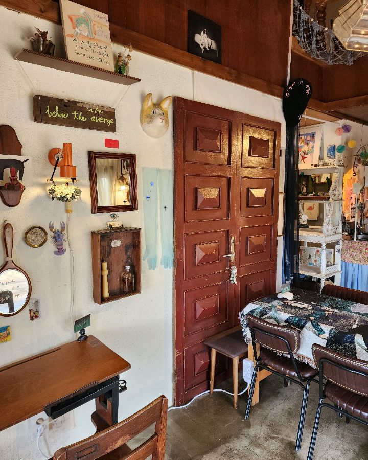 빈티지 가구와 소품들이 조화롭게 어우러진 카페 내부, 독특한 분위기를 자아낸다.