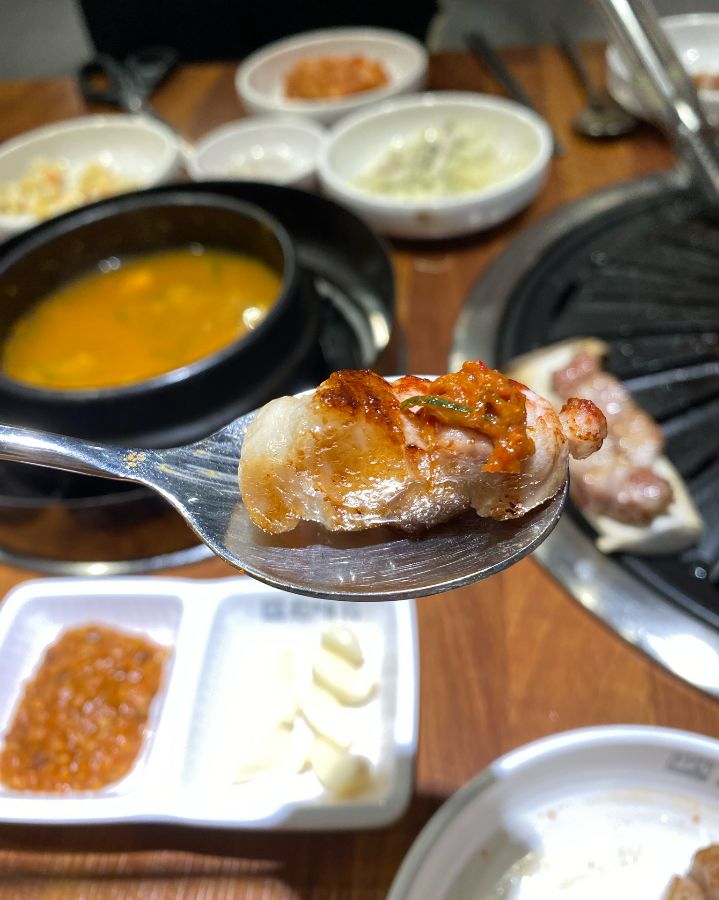 잘 익은 고기를 소스에 찍어 먹는 모습