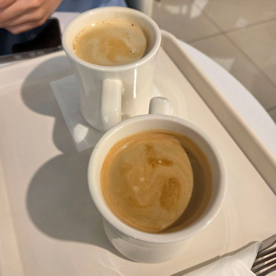 깔끔한 흰색 머그컵에 담겨 나온 따뜻한 아메리카노